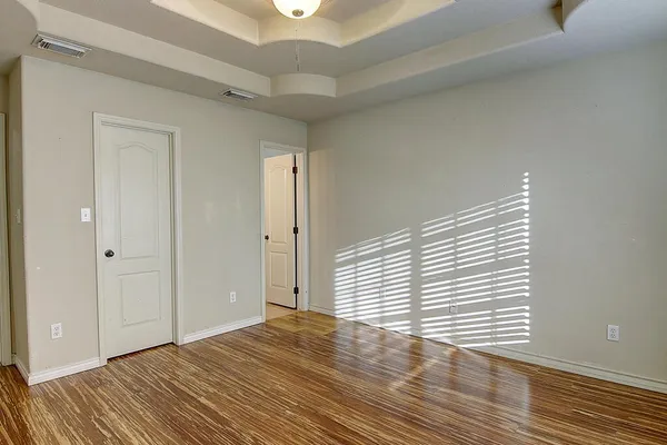 a view of an empty room with wooden floor