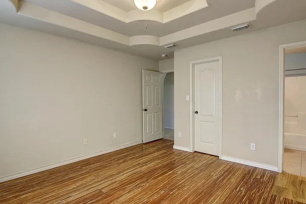 a view of an empty room with wooden floor