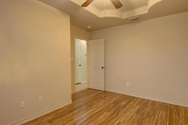 a view of an empty room with wooden floor