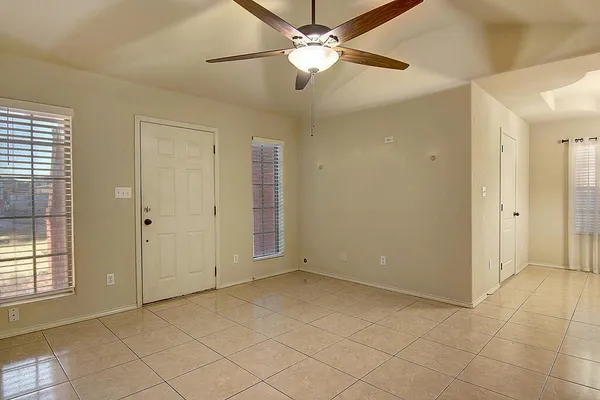 an empty room with fan and windows