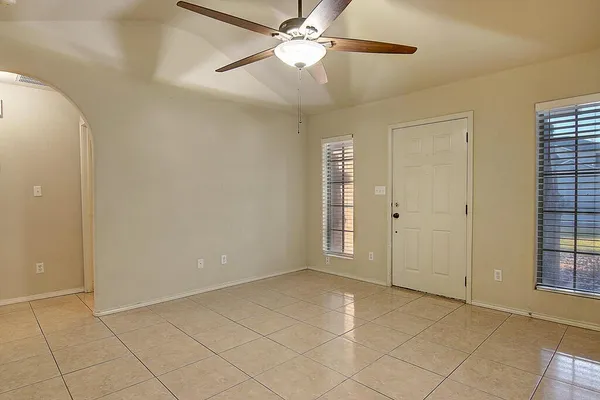 an empty room with windows and fan