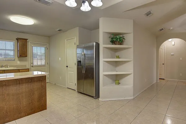 a view of a kitchen with refrigerator and window