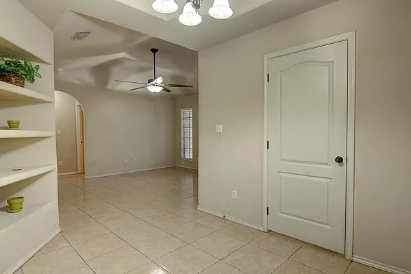 a view of a hallway with a chandelier fan and closet