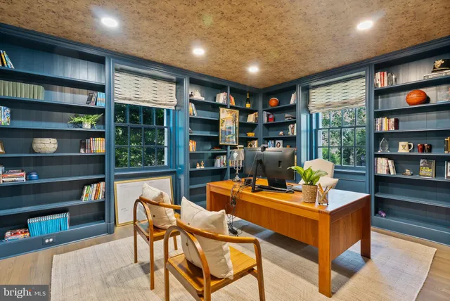 a reading room with furniture book shelf and a floor to ceiling window