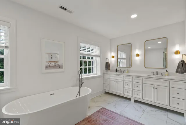 a bathroom with a tub a sink shower double vanity