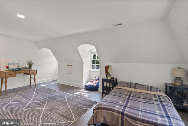 a bedroom with a bed a table and chair