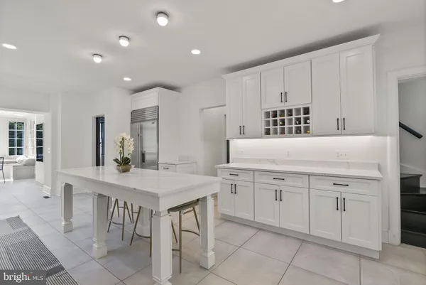 a kitchen with a sink table and chairs