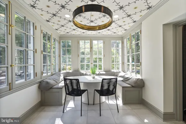 a view of a dining room with furniture large windows and a chandelier