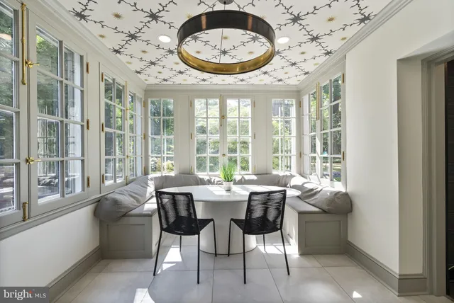 a view of a dining room with furniture large windows and a chandelier
