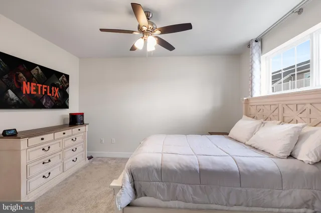 a bedroom with a bed and a flat tv screen on dresser