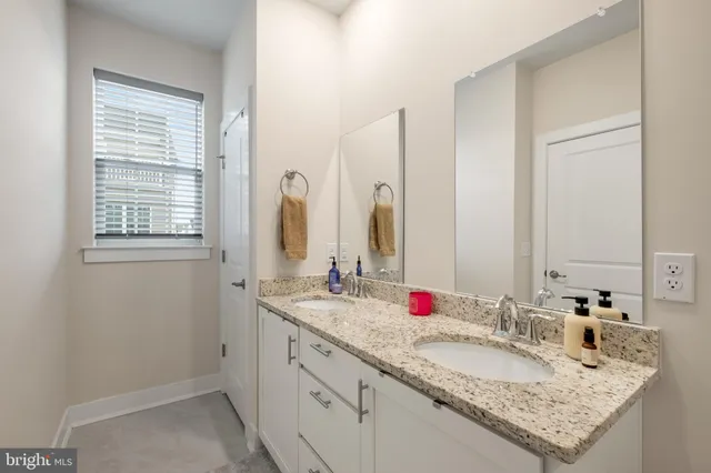 a bathroom with a granite countertop sink and a mirror