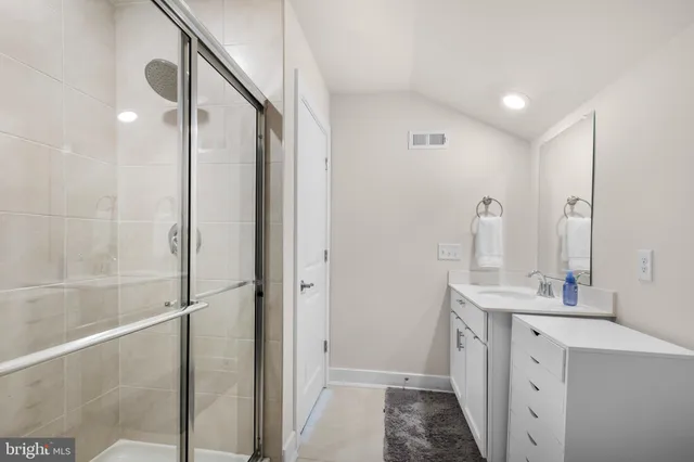 a bathroom with a double vanity sink a mirror and a shower
