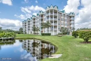 a view of a large building with a yard and lake view