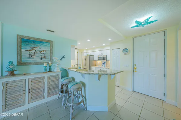 a kitchen with kitchen island granite countertop furniture a sink a window and stainless steel appliances