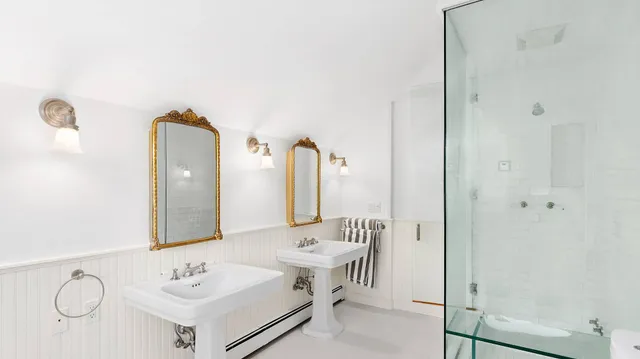 a bathroom with a double vanity sink mirror and shower