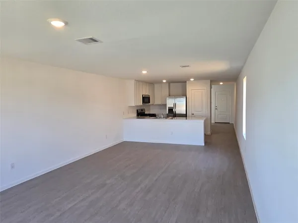 a kitchen with granite countertop a refrigerator sink and microwave