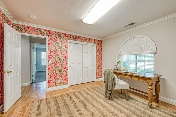 a view of a room with wooden floor and furniture