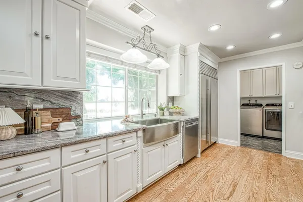 a kitchen with a sink dishwasher a refrigerator and cabinets
