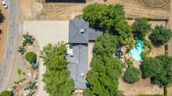 an aerial view of a house with a yard and garden