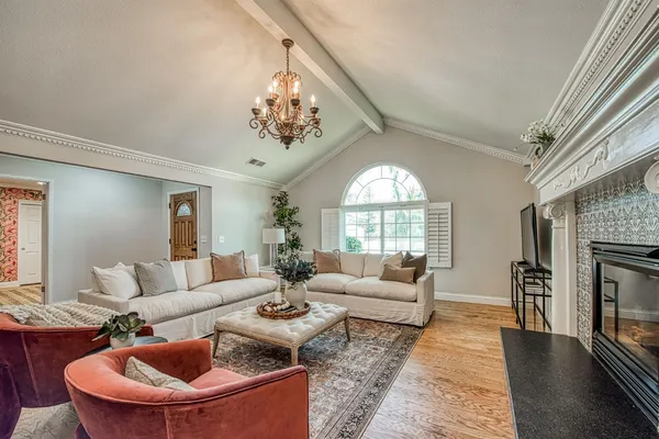 a living room with furniture a chandelier and a fireplace