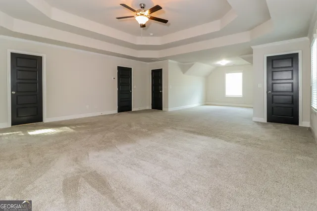 a view of an empty room with a ceiling fan