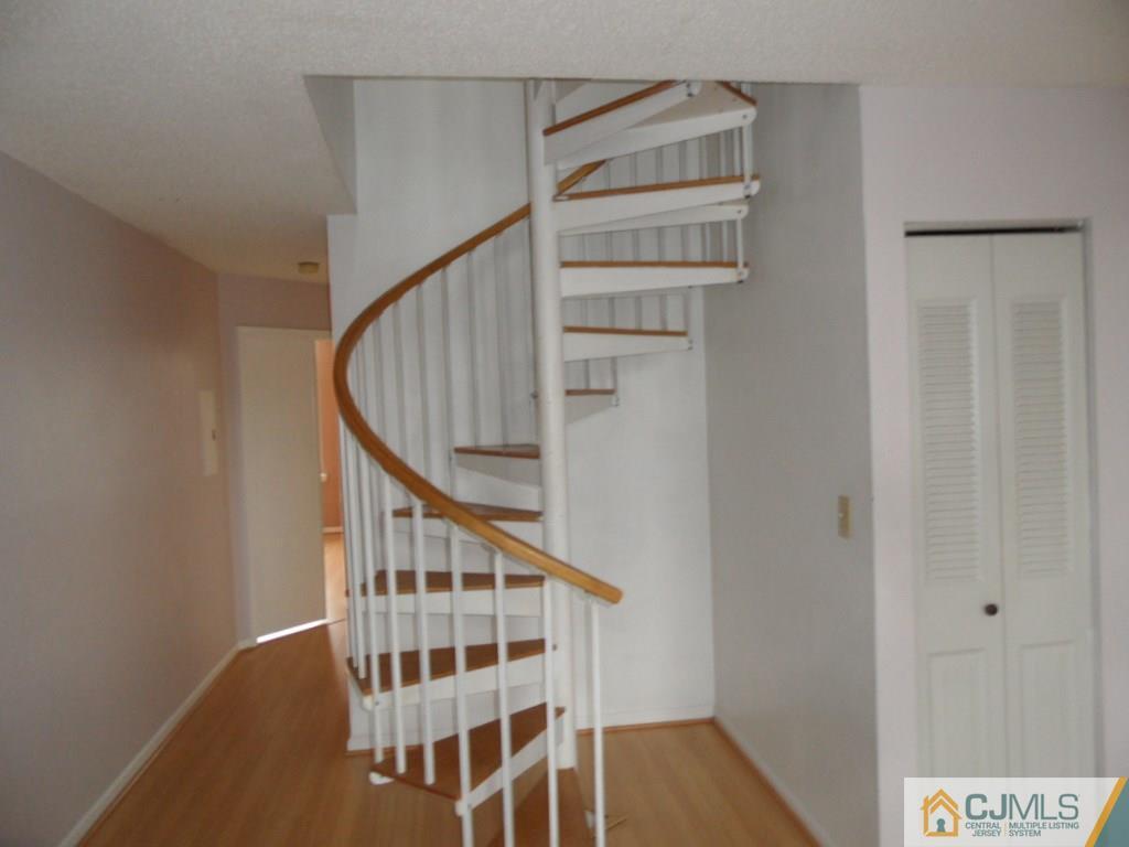 432 Edpas Road, Unit 432 New Brunswick, NJ 08901 - Photo 19 of 22 a view of staircase with wooden floor and white walls
