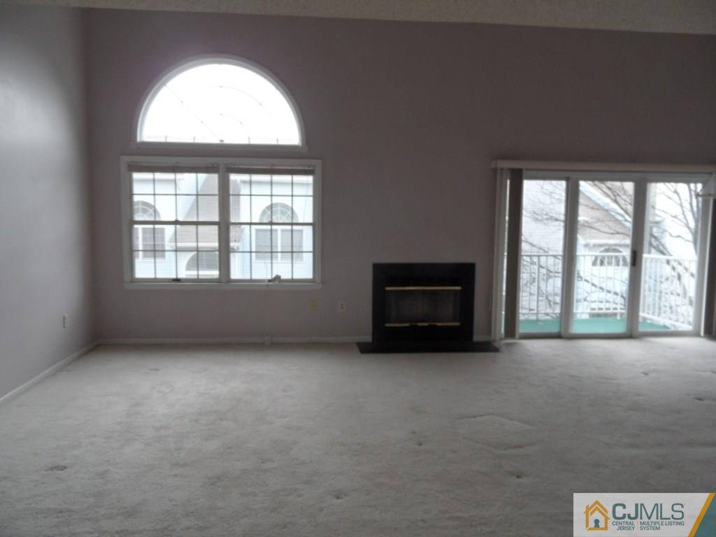 432 Edpas Road, Unit 432 New Brunswick, NJ 08901 - Photo 3 of 22 an empty room with a fireplace and large windows