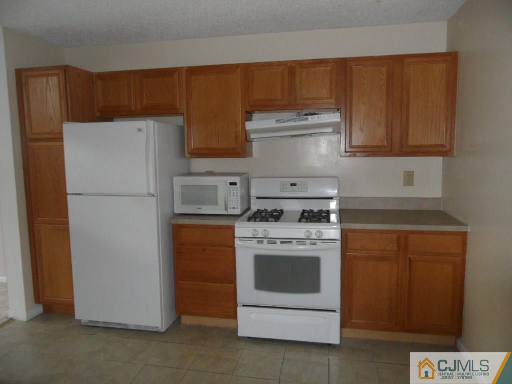 432 Edpas Road, Unit 432 New Brunswick, NJ 08901 - Photo 9 of 22 a kitchen with a refrigerator stove and white cabinets