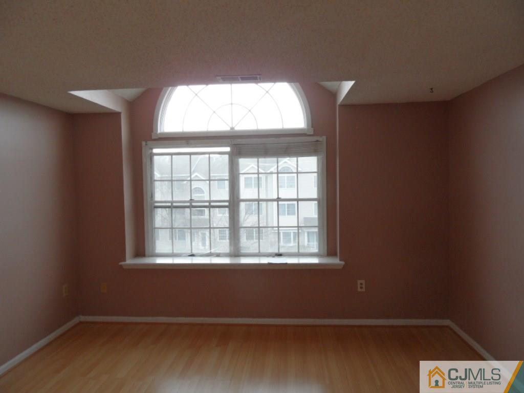 432 Edpas Road, Unit 432 New Brunswick, NJ 08901 - Photo 10 of 22 an empty room with wooden floor and windows