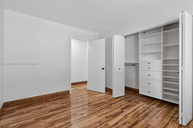 a view of an empty room with cabinet and a window