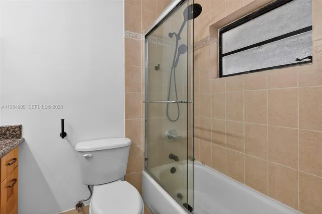 a white toilet sitting next to a bath tub