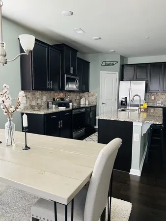 a kitchen with stainless steel appliances kitchen island granite countertop a sink and cabinets