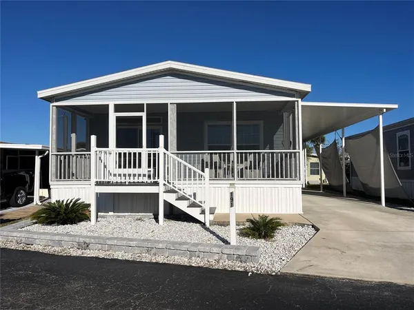 a front view of a house with a yard outdoor seating and garage