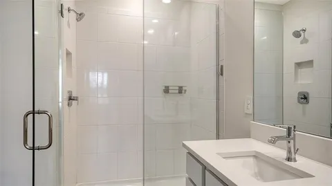 a bathroom with a granite countertop shower sink and vanity