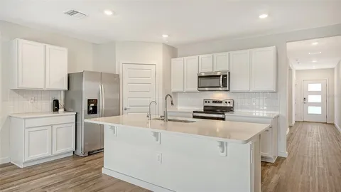 a kitchen with a sink a stove a refrigerator and cabinets