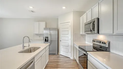 a kitchen with stainless steel appliances a sink stove and refrigerator
