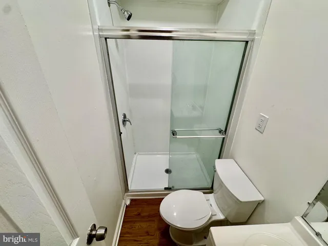 a white toilet sitting next to a shower
