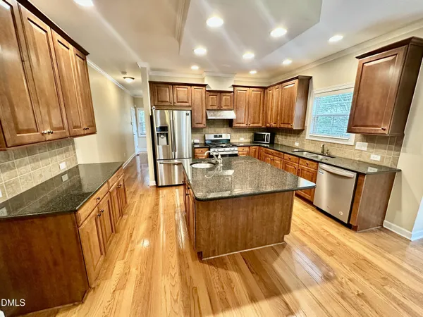 a kitchen with stainless steel appliances granite countertop a sink stove and refrigerator