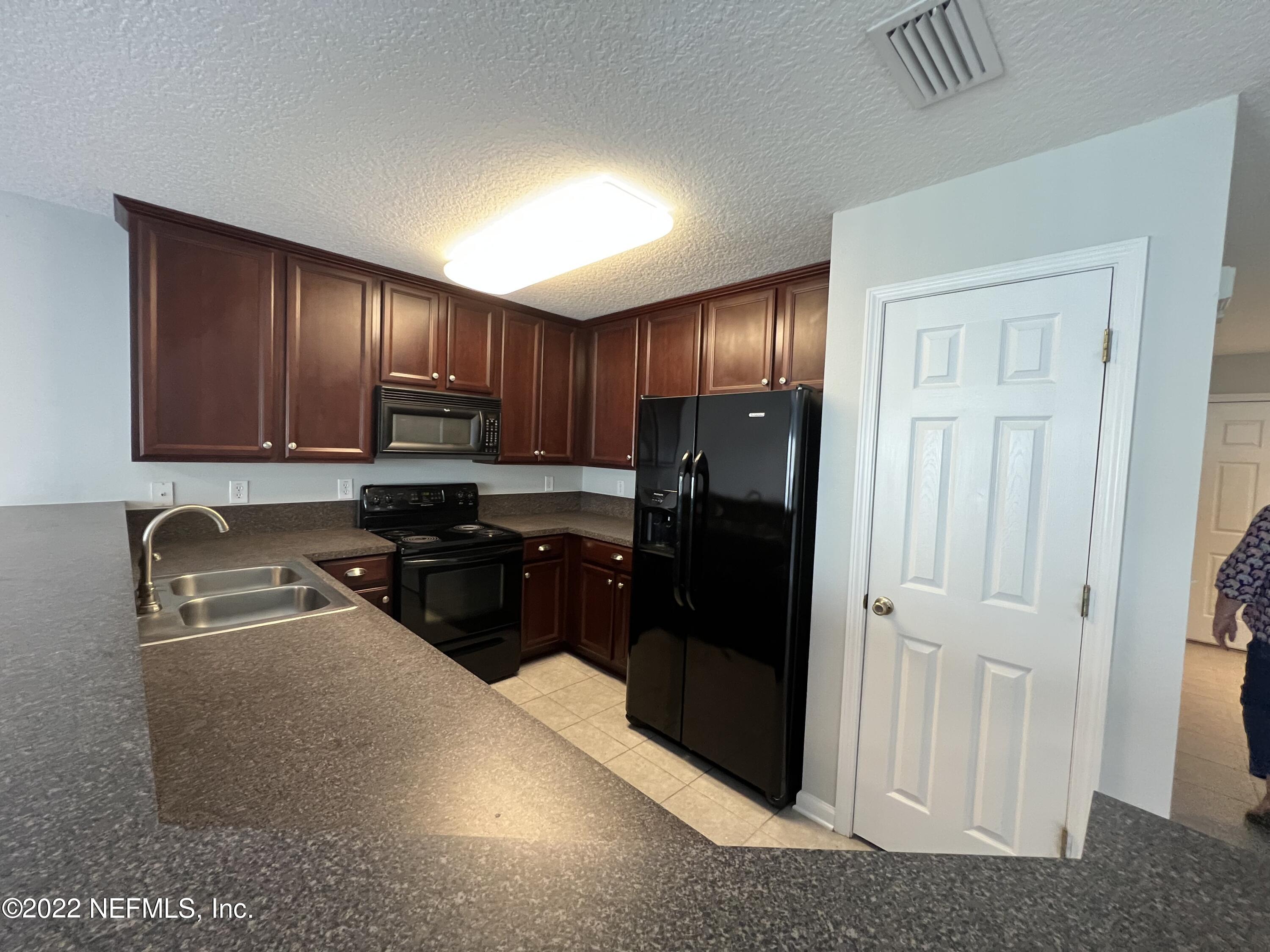 6700 Bowden Road, Unit 802 Jacksonville, FL 32216 - Photo 8 of 19 a kitchen with granite countertop wooden cabinets and stainless steel appliances