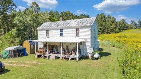 a view of a patio with table and chairs under an umbrella with large trees