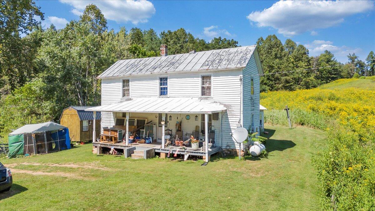 5741 Providence Church Road Ferrum, VA 24088 - Photo 3 of 52 a view of a patio with table and chairs under an umbrella with large trees
