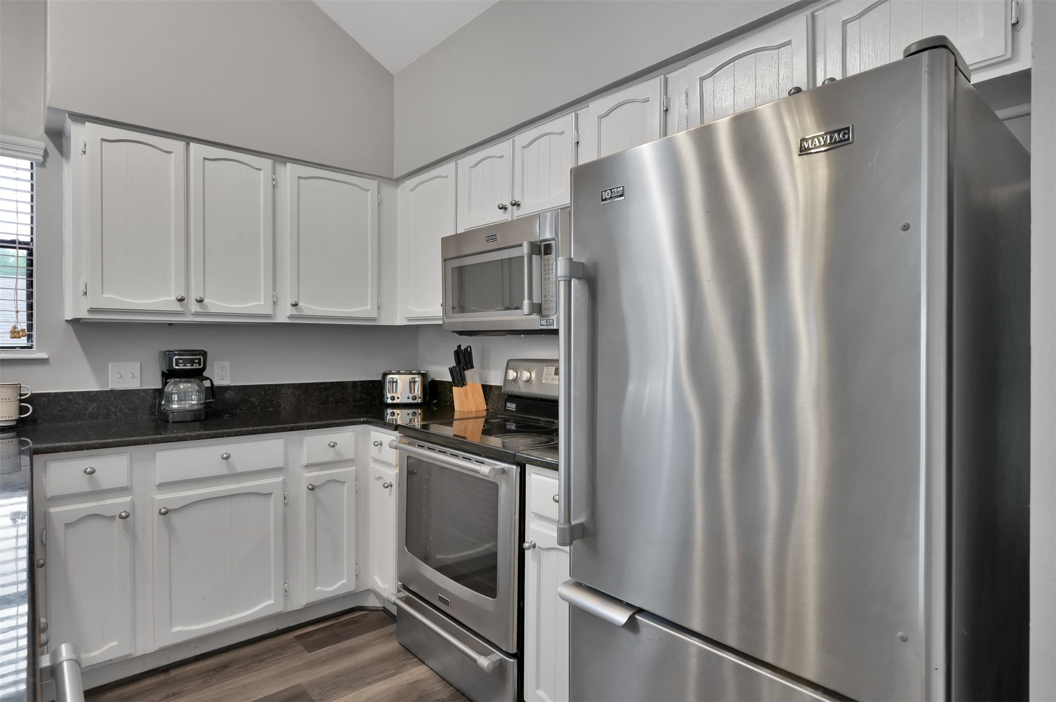 124 April Point Drive North Montgomery, TX 77356 - Photo 11 of 26 a kitchen with stainless steel appliances granite countertop a refrigerator sink and white cabinets