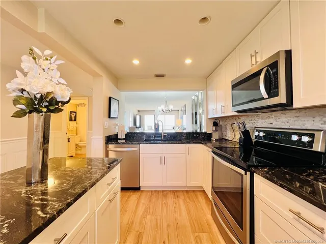 a kitchen with sink a stove and cabinets