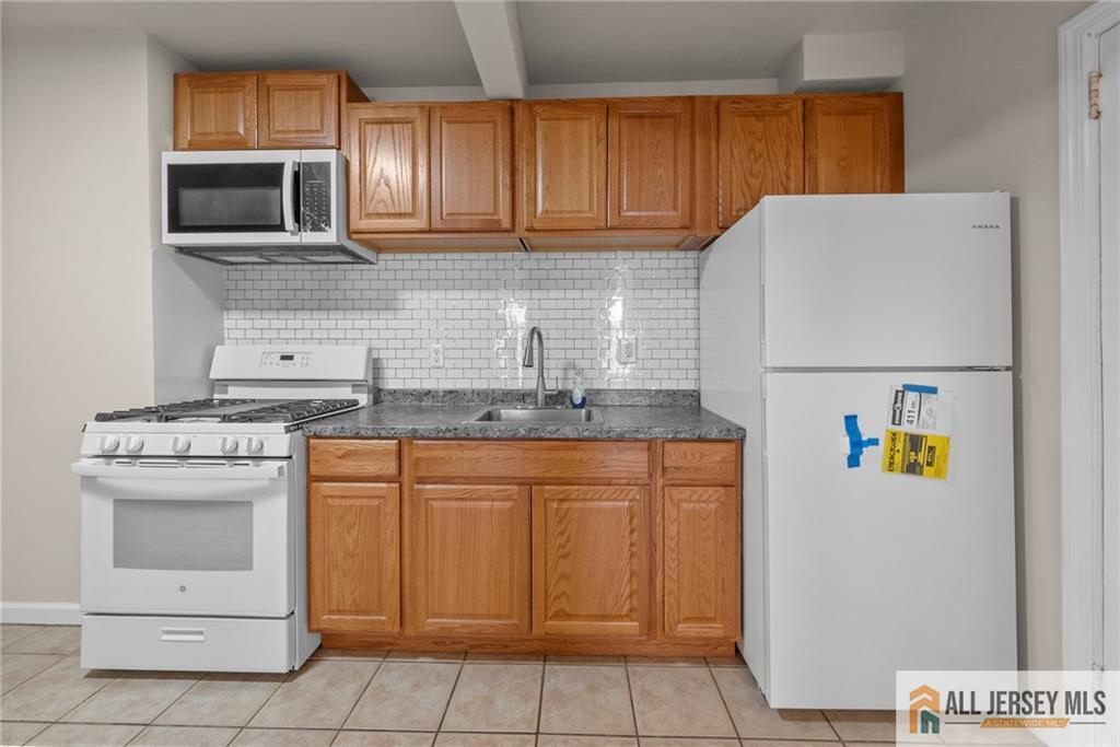 2102 Woodbridge Avenue, Unit 2 Edison, NJ 08817 - Photo 3 of 19 a kitchen with stainless steel appliances granite countertop a refrigerator and a stove top oven
