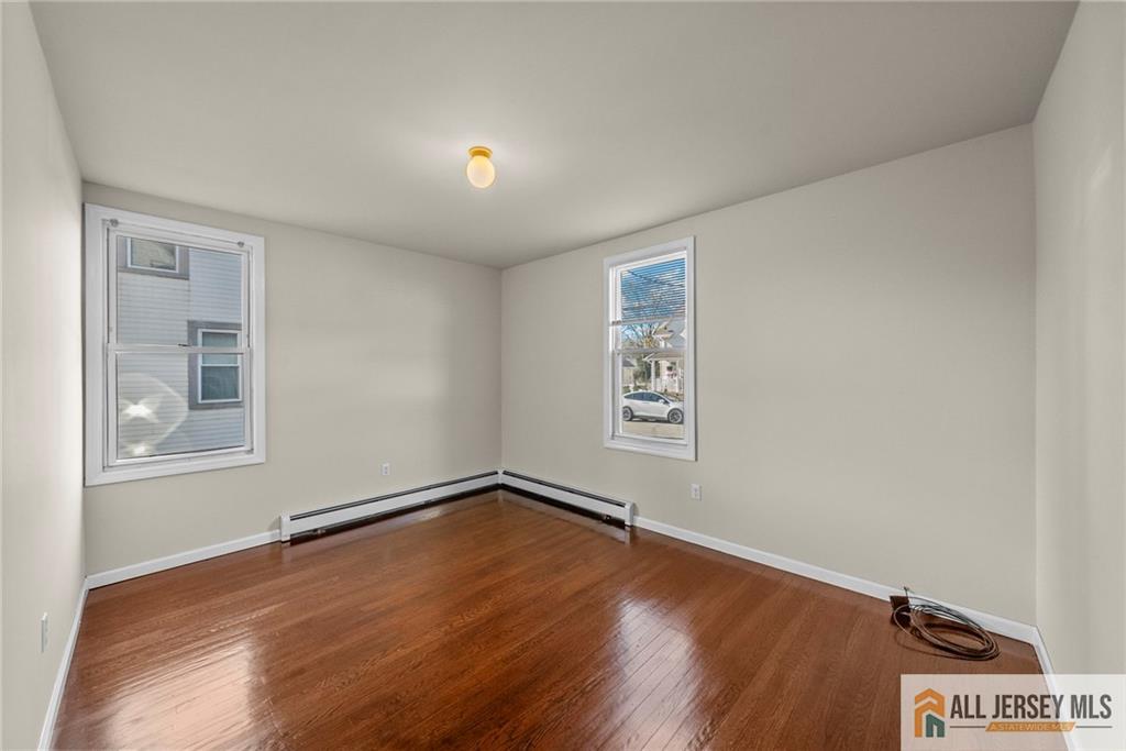 2102 Woodbridge Avenue, Unit 2 Edison, NJ 08817 - Photo 7 of 19 an empty room with wooden floor and windows