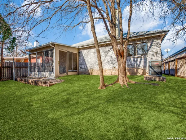 a view of a house with backyard and a tree