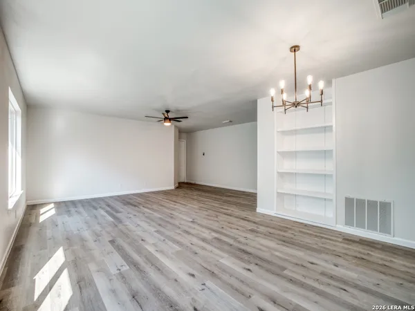 a view of empty room with wooden floor