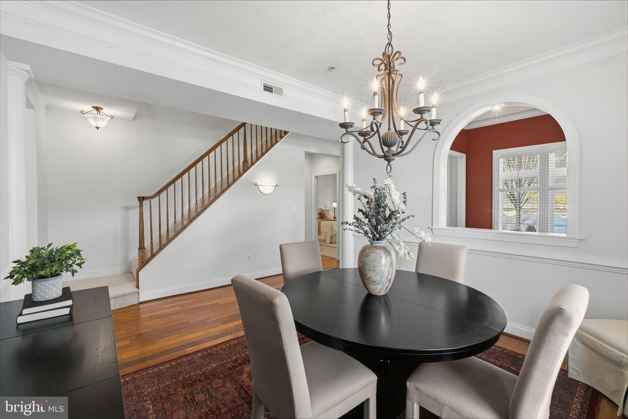 2607 Buckingham Road, Unit 78 Ellicott City, MD 21043 - Photo 5 of 43 a dining room with wooden floor a chandelier a wooden table and chairs