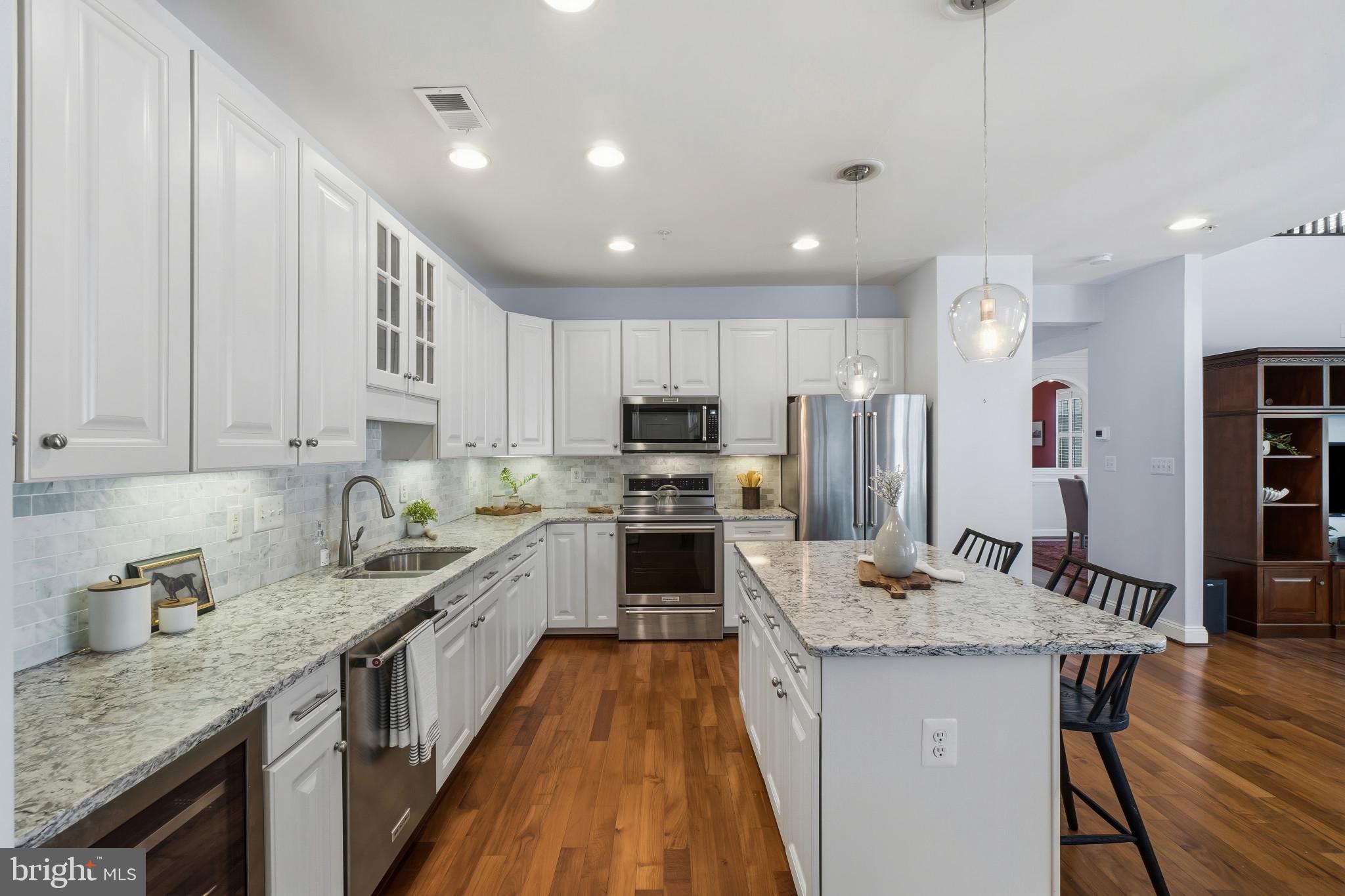 2607 Buckingham Road, Unit 78 Ellicott City, MD 21043 - Photo 7 of 43 a kitchen with kitchen island granite countertop wooden cabinets a sink a stove a oven and a refrigerator