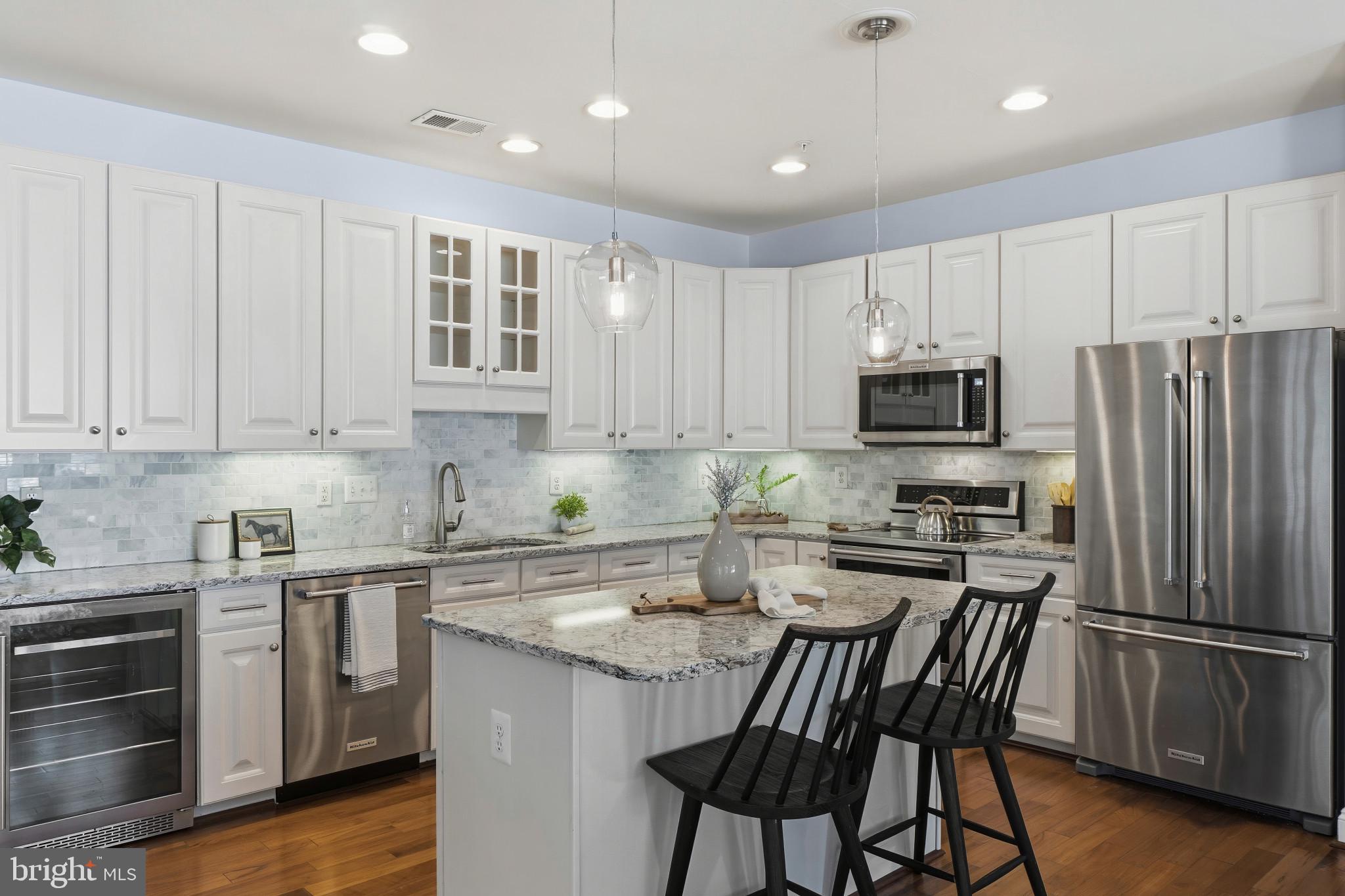 2607 Buckingham Road, Unit 78 Ellicott City, MD 21043 - Photo 8 of 43 a kitchen with stainless steel appliances granite countertop a stove a sink dishwasher a refrigerator with white cabinets and wooden floor